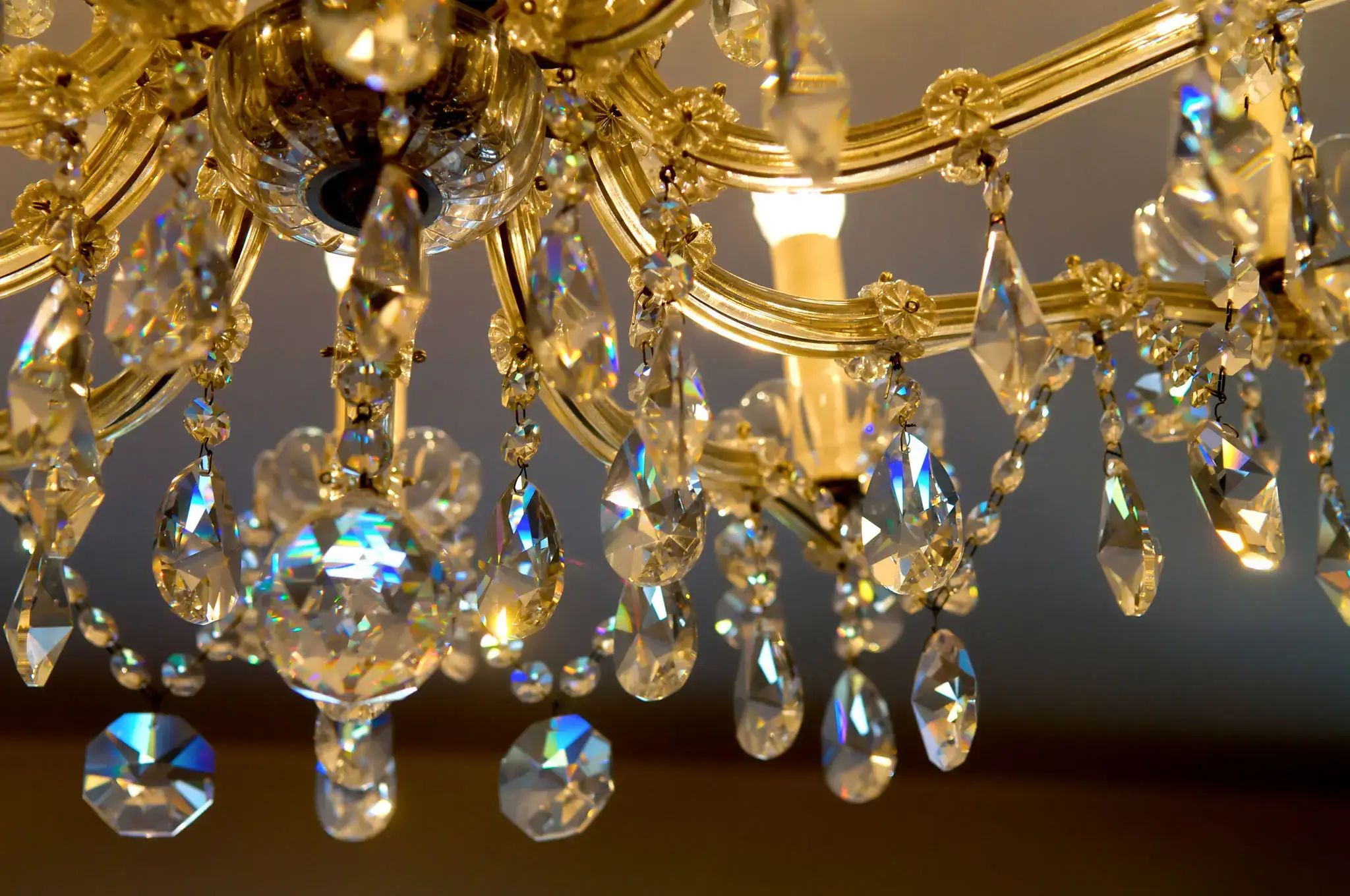 Close-up of a crystal chandelier with light reflecting through the prisms.